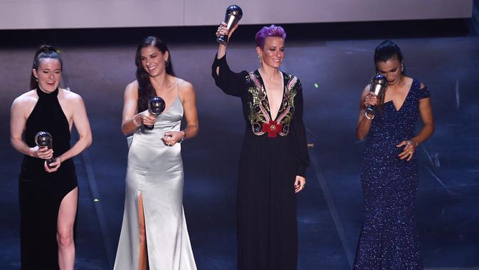 Penyerang Amerika Serikat, Megan Rapinoe (kedua kanan) mengangkat trofi pemain Wanita FIFA Terbaik 2019 saat berpose bersama Rose Lavelle, Alex Morgan dan Marta teater La Scala Milan, Italia utara (23/9/2019). (AFP Photo/Marco Bertorello)