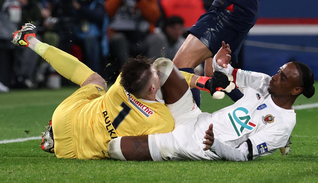 Wajah kiper Nice, Marcin Bulka menabrak lutut rekannya sendiri, Pablo Rosario pada laga perempat final Coupe de France 2023/2024 melawan PSG di Stadion Parc des Princes, Paris, Prancis, Kamis (14/03/2024) dini hari WIB. (AFP/Franck Fife)