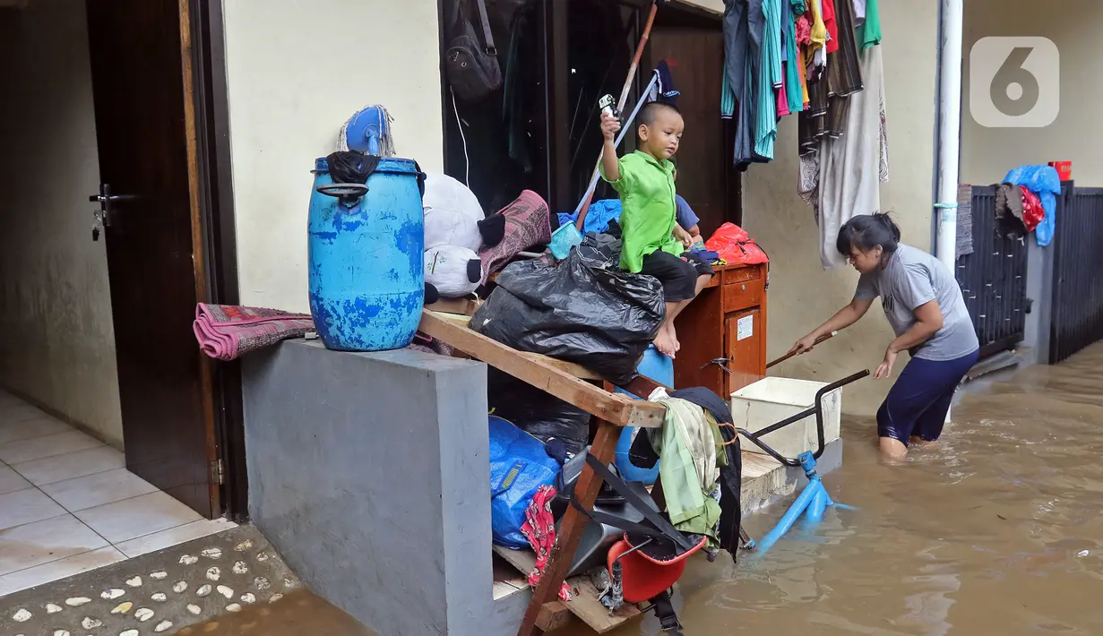 Warga membersihkan rumahnya saat banjir di RW 06 kawasan Mekarsari, Depok, Jawa Barat, Sabtu (20/2/2021). Banjir yang disebabkan meluapnya aliran Kali Cipinang Timur ini terjadi akibat intensitas hujan tinggi di wilayah tersebut (Liputan6.com/Herman Zakharia)