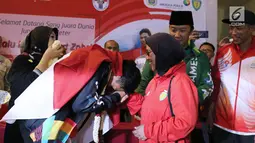 Pelari muda Indonesia, Lalu Muhammad Zohri (kiri) mencium tangan pelatih pelatnas, Eni Nuraini saat penyambutan di Terminal 3 Bandara Soetta, Tangerang, Selasa (17/7). Lalu M Zohri meraih emas lari 100m putra U-20 IAAF. (Liputan6.com/Helmi Fithriansyah)