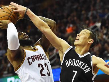 Pemain Cleveland Cavaliers, LeBron James (kiri) mencoba memasukan bola saat dihadang pemain Brooklyn Nets,  Jeremy Lin (kanan) pada lanjutan NBA di Quicken Loans Arena, (23/12/2016). (Reuters/Ken Blaze-USA TODAY Sports)