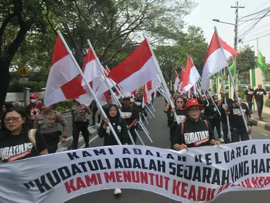 Ratusan orang melakukan aksi berjalan kaki sambal membawa poster dan bendera dari kantor Dewan Pimpinan Pusat (DPP) Partai Demokrasi Indonesia Perjuangan (PDIP) menuju gedung Komisi Nasional Hak Asasi Manusia (Komnas HAM), Jakarta, Jumat (26/7/2024). (merdeka.com/Imam Buhori)