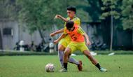 Pemain muda Arema, Achmad Figo (kuning tanpa rompi) saat dihadang rekannya dalam latihan. (Iwan Setiawan/Bola.com)
