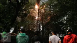 Sejumlah warga melihat percikan api yang keluar dari kabel listrik setelah hujan deras mengguyur sore ini, di Jalan Imam Bonjol No 2, Jakarta, Selasa (28/3). (Liputan6.com/JohanTallo)