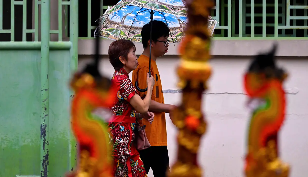Orang-orang berjalan untuk berdoa di sebuah pura pada hari pertama Tahun Baru Imlek 2577 Kongzili di Banda Aceh, Provinsi Aceh, pada Selasa 17 Februari 2026. (CHAIDEER MAHYUDDIN/AFP)
