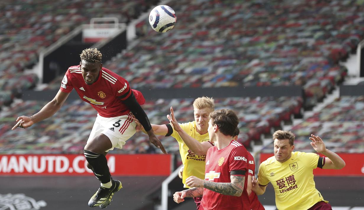 Gelandang Manchester United, Paul Pogba, menyundul bola saat melawan Burnley pada laga Liga Inggris di Stadion Old Trafford, Minggu (18/4/2021). MU menang 3-1 Burnley. (Martin Rickett/Pool via AP)