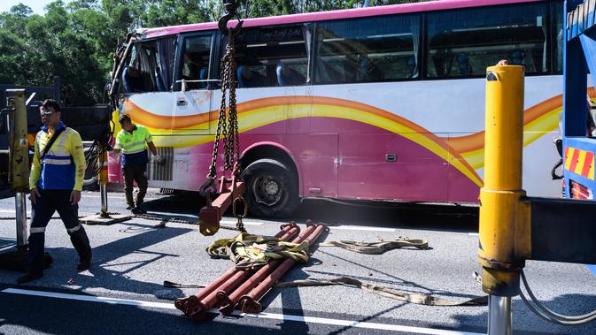 Sejumlah petugas mengevakuasi sebuah bus setelah bertabrakan dengan taksi di Hong Kong (30/11). Lima orang tewas dan 32 luka-luka setelah akibat kecelakaan tersebut. (AFP Photo/Anthony Wallace)