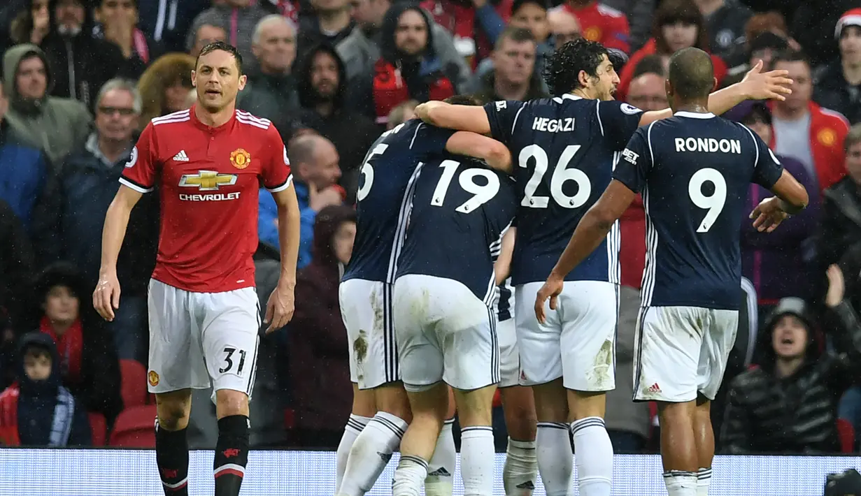 Gelandang Manchester United, Nemanja Matic (kiri) berjalan saat para pemain West Bromwich Albion merayakan gol yang dicetak Jay Rodriguez di Old Trafford, Inggris (15/4). MU kalah 0-1 atas West Bromwich Albion. (AFP Photo/Paul Ellis)