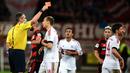 Wasit Knut Kircher, memberikan kartu merah kepada gelandang Bayern Munchen, Xabi Alonso saat laga melawan Leverkusen. Kini Munchen unggul delapan poin dari Dortmund yang berada pada posisi kedua. (AFP/Patrik Stollarz)