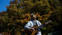 Kyochi Watanabe memainkan musik di hutan Aokigahara, dengan harapan agar tak ada lagi orang yang ingin bunuh diri karena putus asa di hutan tersebut. (AFP File)