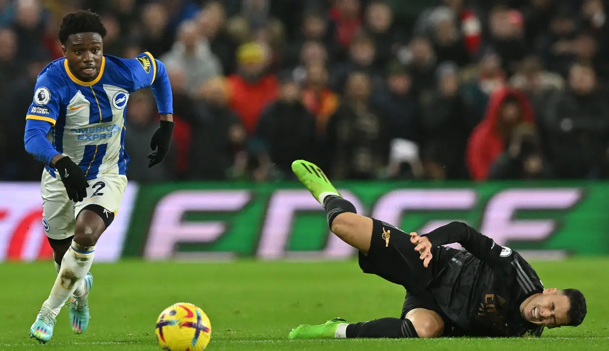 Gelandang Brighton abd Hove Albion, Tariq Lamptey berusaha melewati gelandang Arsenal, Gabriel Martinelli pada laga Liga Inggris 2022/2023 di American Express Community Stadium, Brighton (31/12/2022). Tariq Lamptey didatangkan Brighton and Hove Albion pada paruh musim 2019/2020 dari Chelsea dengan nilai transfer hanya 1,2 juta euro dan masih menyisakan kontrak dua tahun lagi. Crystal Palace dan Chelsea menjadi dua klub yang dibelanya sepanjang kariernya. (AFP/Glyn Kirk)