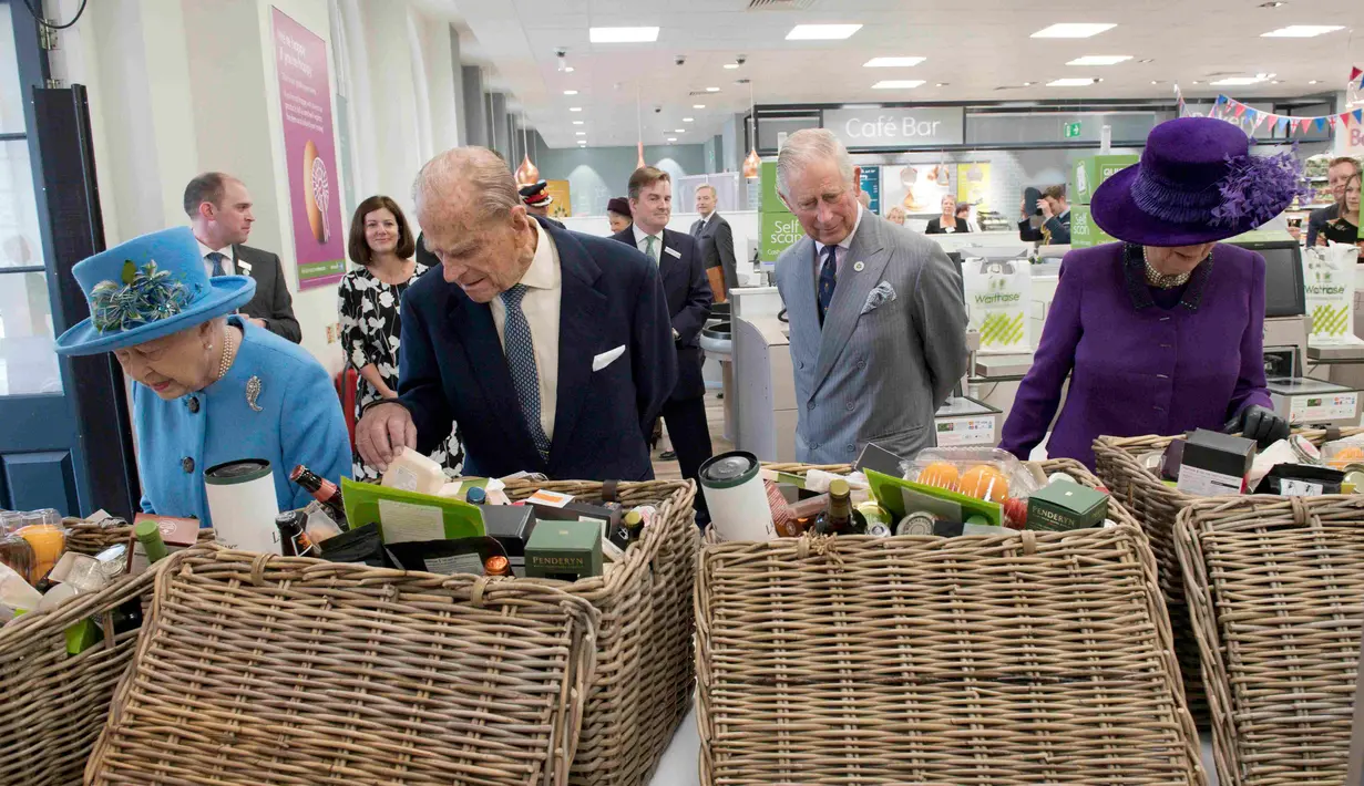 Ratu Inggris Elizabeth II, Pangeran Philip, Pangeran Charles berserta istrinya Ratu Camilla, melihat makanan yang dijual di pasar swalyan Waitrose saat kunjungannya ke Kota Poundbury, Inggris (27/10). (Reuters/Justin Tallis)