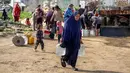 Hingga Februari 2026, krisis air bersih di Gaza telah mencapai titik yang sangat kritis, dengan ketersediaan air yang anjlok drastis akibat kerusakan masif pada infrastruktur vital. Tampak dalam foto, warga mengisi wadah air dari tangki air portabel di kamp pengungsi Palestina Maghazi, Jalur Gaza tengah pada Rabu 11 Februari 2026. (Eyad BABA/AFP)