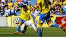 Pemain Real Madrid, Karim Benzema (tengah) berusaha merebut bola dari kaki pemain Las Palma, Ximo Navarro pada lanjutan La Liga Santander di Gran Canaria stadium, Canary island, (31/3/2018). Madrid menang 3-0. (AP/Lucas de Leon)