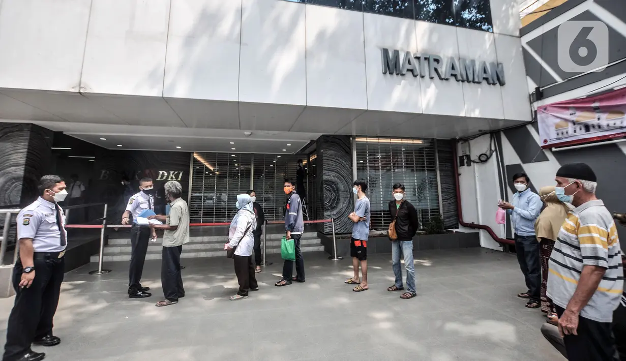 Warga antre untuk mencairkan dana bantuan sosial tunai (BST) di ATM Bank DKI kawasan Matraman, Jakarta, Rabu (21/7/2021). BST disalurkan melalui rekening Bank DKI sebesar Rp 600 ribu per KK yang merupakan rapelan tahap 5 dan 6 atau bulan Mei dan Juni. (merdeka.com/Iqbal S. Nugroho)