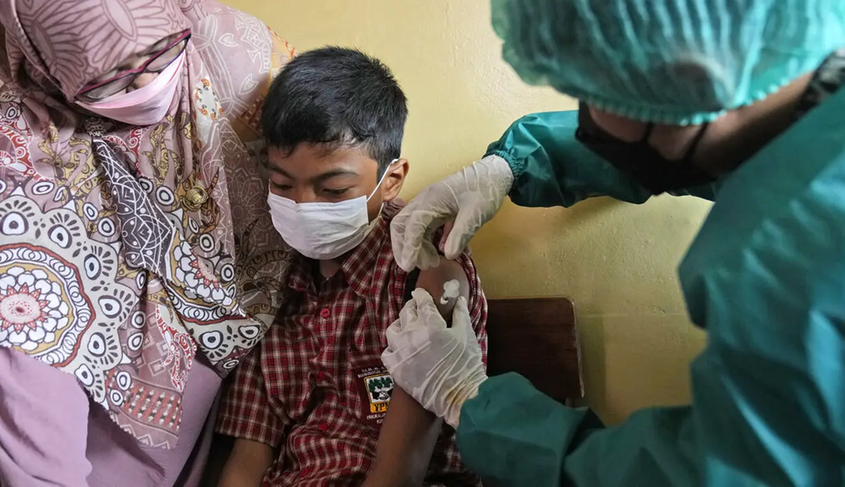 Seorang siswa disuntik vaksin COVID-19 pada kampanye vaksinasi di sebuah sekolah untuk anak-anak berkebutuhan khusus di Depok, Jawa Barat, Selasa (11/1/2022). Kampanye vaksinasi ini dilakukan oleh Polri. (AP Photo/Dita Alangkara)