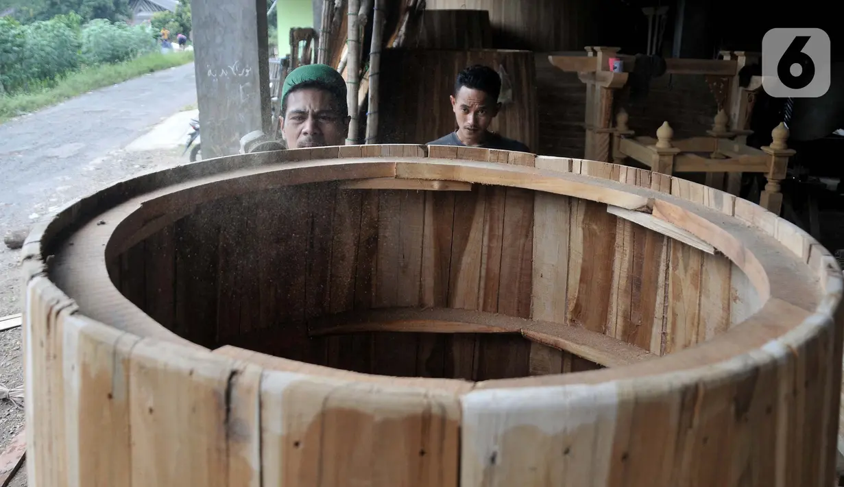 <p>Perajin menyelesaikan pembuatan beduk Al Mubarok di Desa Gumulung, Kecamatan Greged, Kabupaten Cirebon, Jawa Barat pada akhir Maret 2022 lalu.Untuk pembuatan beduk raksasa berbahan kayu jati ini biasanya dapat diselesaikan dalam seminggu. Beduk Al Mubarok dijual mulai dari Rp7 juta untuk ukuran 60cmx100cm hingga ratusan juta rupiah untuk ukuran yang lebih besar, tergantung jenis kayu dan kulit. (merdeka.com/Iqbal S Nugroho)</p>