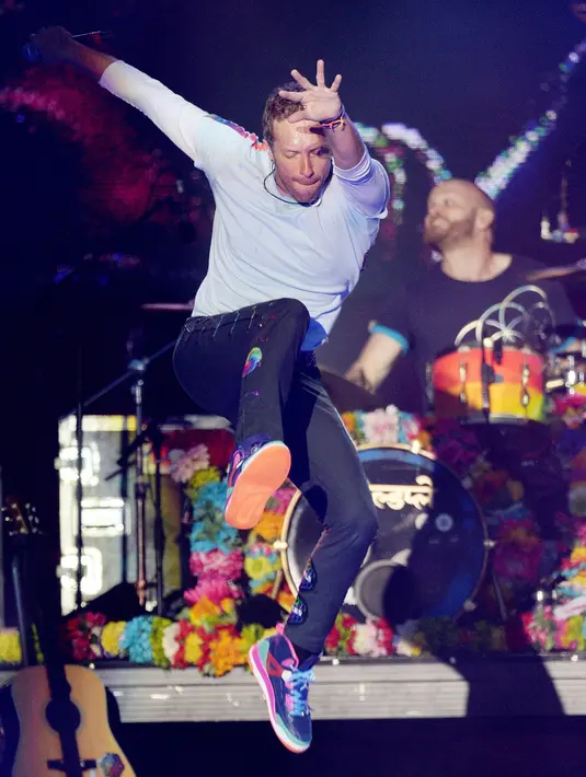 Vokalis Coldplay, Chris Martin membawakan lagu dalam konser amal bertajuk "One Love Manchester" di Manchester, Minggu (4/6). Konser itu untuk mengenang dan menggalang dana bagi para korban bom di konser Ariana Grande 22 Mei silam. (Dave Hogan via AP)