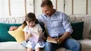 Seorang ayah bersama putrinya sedang membaca buku bersama, tersrirat kebahagiaan dalam raut wajah mereka berdua. Potret ini seperti membawa kembali ke masa kecil. (zEdward_Indy/ Shutterstock.com)
