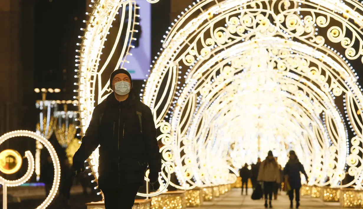 Seorang pria berjalan melewati lorong berhias lampu yang dipasang untuk menyambut libur Tahun Baru dan Natal Ortodoks di Moskow, Rusia, pada 29 Desember 2020. (Xinhua/Alexander Zemlianichenko Jr)
