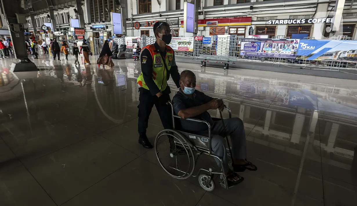 Petugas mendorong kursi roda penumpang KRL Comuterline di Stasiun Jakarta Kota, Jakarta, Rabu (28/10/2020). Mengantisipasi lonjakan penumpang saat cuti bersama dan Sumpah Pemuda, PT KCI mengajak pengguna KRL bersatu dan bangkit melawan COVID-19 dengan menerapkan 3M. (Liputan6.com/Johan Tallo)