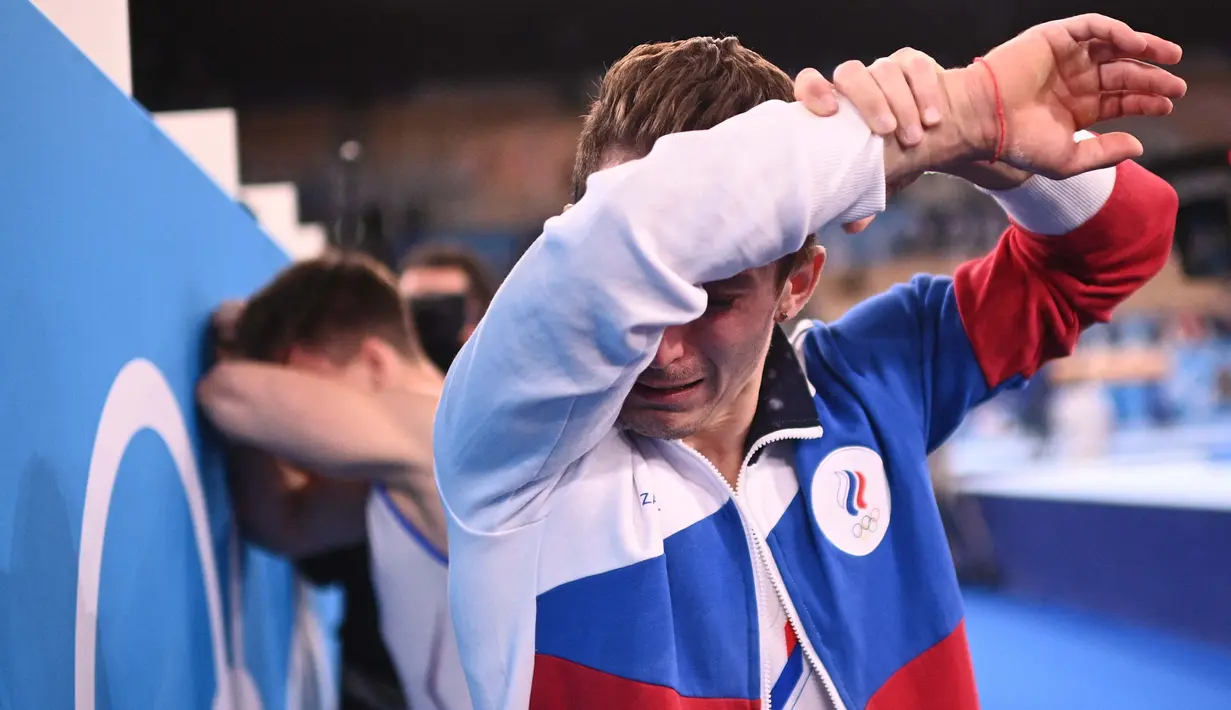 Atlet Komite Olahraga Rusia, Denis Abliazin mengusap air mata usai memenangkan final beregu putra senam artistik Olimpiade Tokyo 2020 di Ariake Gymnastics Center di Tokyo, Senin (26/7/2021). (Foto: AFP/Martin Bureau)