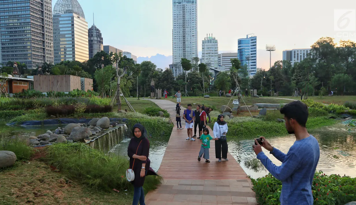Warga berfoto di Hutan Kota kawasan Gelora Bung Karno, Jakarta, Minggu (6/1). Warga Jakarta kini memiliki alternatif wisata untuk menghabiskan akhir pekan. (Liputan6.com/JohanTallo)