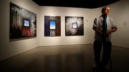 Seniman Ejay Weiss berdiri di depan karya lukisnya berjudul '9/11 Elegies' yang dipamerkan di National September 11 Memorial and Museum, Manhattan, AS (1/9). Pameran ini diikuti oleh 13 seniman asal New York. (REUTERS/Andrew Kelly)