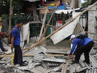 Petugas gabungan melakukan penertiban lapak dan bangunan liar di sepanjang jalur kereta di kawasan Grogol, Jakarta Barat, Kamis (22/2). Penertiban tersebut untuk mensterilkan jalur kereta dari lapak atau bangunan liar. (Liputan6.com/Arya Manggala)