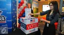 Pengunjung wanita memasukan selembaran voting saat mengikuti simulasi pemilihan Presiden Amerika Serikat di @america di Jakarta, Rabu (9/11). Dalam simulasi ini pengunjung dapat merasakan pemilihan presiden AS mirip aslinya. (Liputan6.com/Angga Yuniar)