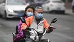 Suami-istri mengenakan masker mengendarai kendaraannya di jalan pada hari yang tercemar polusi udara di Beijing, China (2/4). (AFP Photo/Fred Dufour)