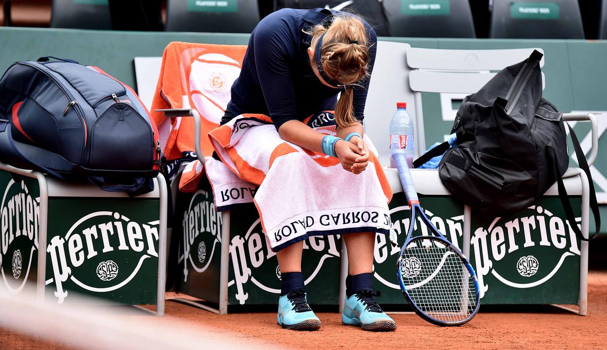 Victoria Azarenka tertunduk menahan sakit saat melawan Karin Knapp pada babak pertama Prancis Terbuka 2016 di Roland Garros, Paris, (24/5/2016). (EPA/Christophe Petit Tesson)