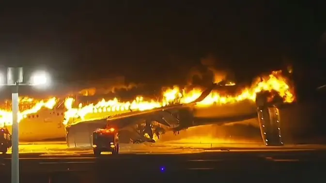 Sebuah pesawat Japan Airlines terbakar di landasan pacu bandara Haneda pada Selasa, 2 Januari 2024 di Tokyo, Jepang. (Screen grab video/AP)