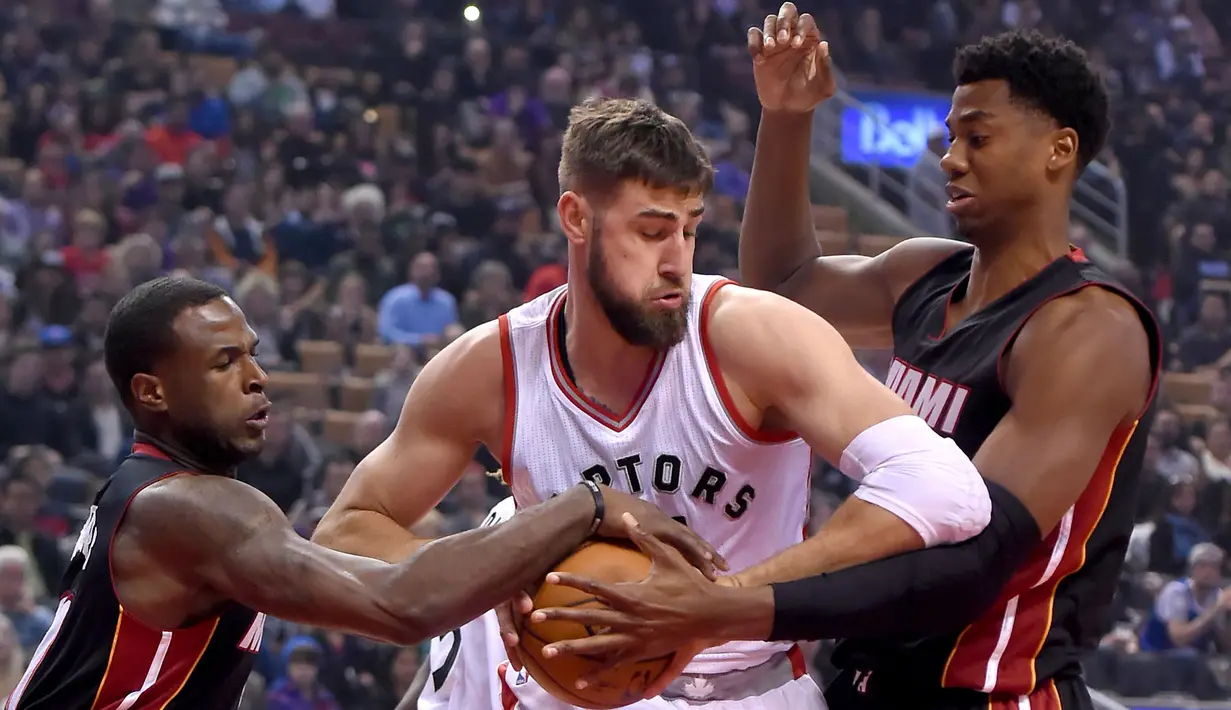 Pemain Toronto Raptors, Jonas Valanciunas (tengah) dihadang pemain Miami Heatpada laga NBA di Air Canada Centre, (4/11/2016). Raptors menang 96-87. (Reuters/Dan Hamilton-USA TODAY Sports)