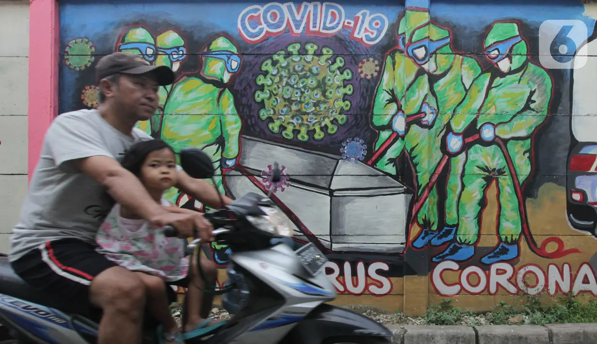 Warga melintasi mural bertema covid-19 di Tanah Tinggi, Tangerang, Sabtu (29/1/2022). Kasus Covid-19 varian Omicron di Indonesia terus bertambah dan wilayah penyebarannya semakin meluas. Diperkirakan, kasus omicron sudah mendominasi penularan virus corona di Jawa Bali. (Liputan6.com/Angga Yuniar)