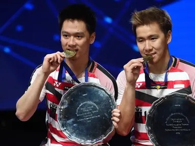 Ganda putra Indonesia, Kevin Sanjaya dan Marcus Gideon merayakan gelar All England di Birmingham, Minggu (18/3/2018). Mereka juara setelah mengalahkan Mathias Boe dan Carsten Mogensen dengan skor 21-18, 21-17. (AFP/Paul Ellis)
