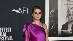 Selena Gomez berpose saat menghadiri pemutaran film "Selena Gomez: My Mind And Me" selama malam pembukaan AFI Fest 2022 di TCL Chinese Theatre di Hollywood, California pada 02 November 2022. Perempuan 30 tahun itu mencuri perhatian  dengan mengenakan gaun sutra magenta cerah yang menampilkan lengan off-shoulder dan side-bow. (AFP/Lisa O’Connor)