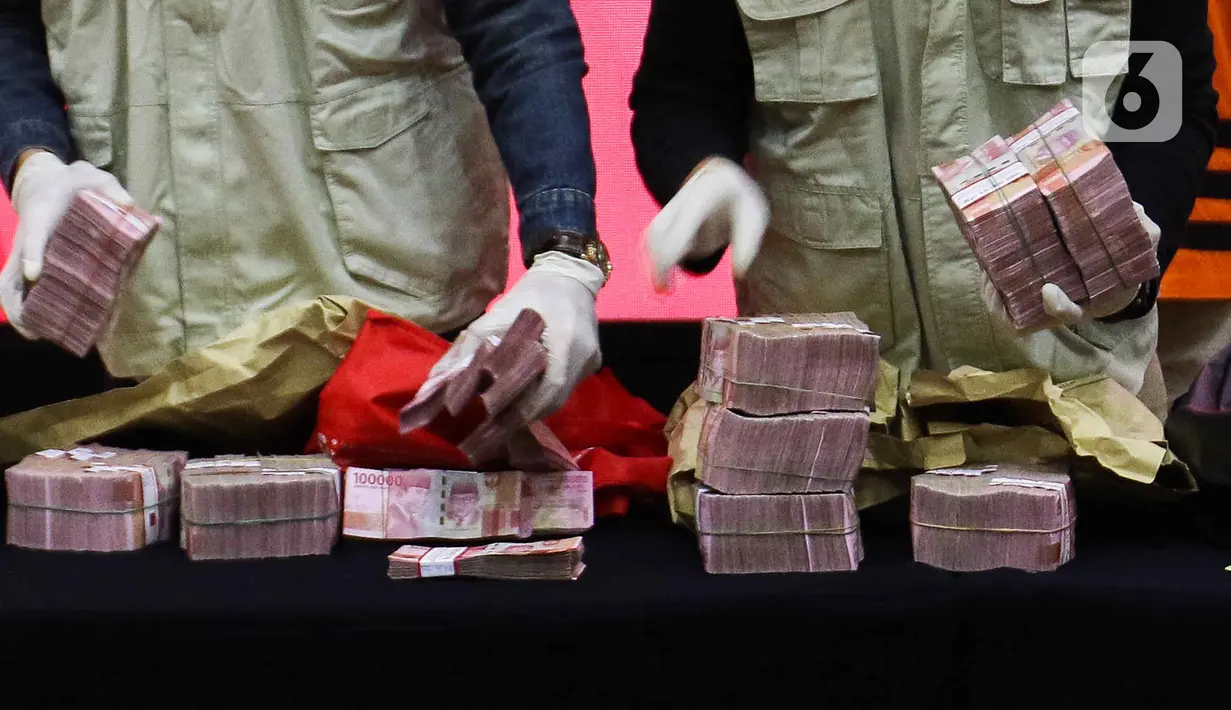 Petugas KPK merapikan barang bukti uang hasil OTT kasus suap pengadaan barang dan jasa Basarnas di Gedung Merah Putih KPK, Jakarta, Rabu (26/7/2023). (Liputan6.com/Herman Zakharia)