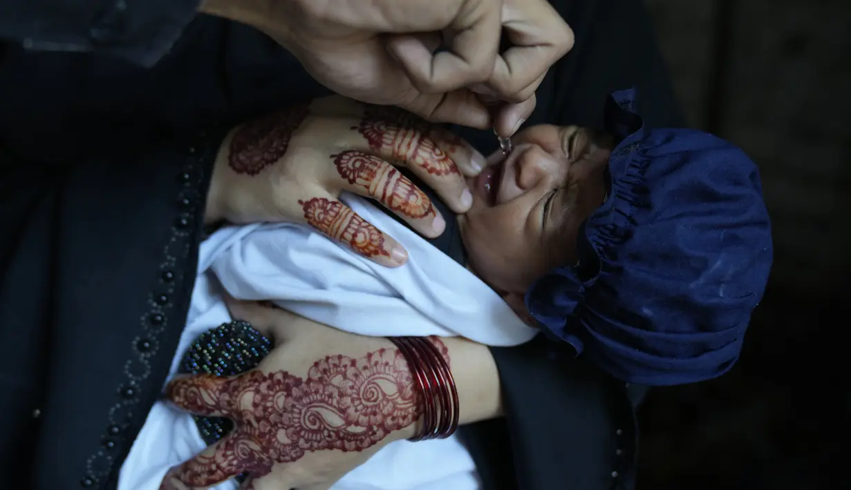 Seorang petugas kesehatan memberikan vaksin polio kepada seorang anak di lingkungan Lahore, Pakistan, Senin, 2 Oktober 2023. (AP Photo/K.M. Chaudary)