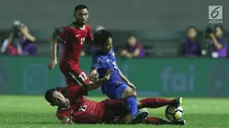Bek Timnas Indonesia U-23, Ricky Fajrin (bawah) menahan pergerakan pemain Thailand U-23, Picha Au-Tra pada laga persahabatan di Stadion Pakansari, Kab Bogor, Minggu (3/6). Laga berakhir imbang 0-0. (Liputan6.com/Helmi Fithriansyah)