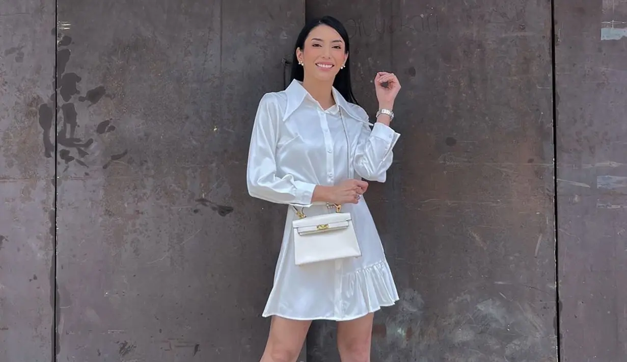 Busana berbahan satin juga menjadi salah satu pilihan OOTD Tyas Mirasih. Bintang film 'The Tarix Jabrix' ini tampil stunning dengan dress putih mini. Gayanya semakin kece dengan tas kecil dengan warna senada. Tak hanya itu, jam tangan yang dikenakannya juga senada. (Liputan6.com/IG/@tyasmirasih)