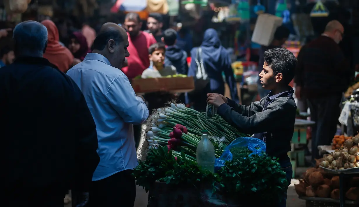 Warga Palestina berbelanja untuk persiapan menjelang bulan suci Ramadan di pasar al-Zawiya di Kota Gaza pada 20 April 2020. Tahun ini, miliaran umat Muslim di dunia bersiap memasuki bulan suci Ramadan di tengah situasi pandemi Covid-19. (MAHMUD HAMS / AFP)