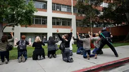 Petugas memeriksa sejumlah orang menyusul penembakan di Universitas California Los Angeles (UCLA), Rabu (1/6). Insiden itu memicu penutupan kampus dan memaksa ratusan mahasiswa yang ketakutan bersembunyi di dalam gedung. (REUTERS/Patrick T. Fallon)