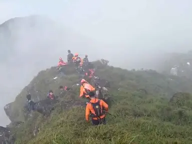 Dalam foto yang disediakan oleh Badan Nasional Pencarian dan Penyelamatan Indonesia (BASARNAS), anggota tim penyelamat melakukan operasi pencarian di sekitar Gunung Bulusaraung, Provinsi Sulawesi Selatan, Indonesia, Sabtu 17 Januari 2026. Minggu 18 Januari 2026, Tim SAR gabungan berhasil menemukan badan pesawat ATR 42-500 di kawasan Gunung Bulusaraung, wilayah perbatasan Kabupaten Maros dan Kabupaten Pangkep, Sulawesi Selatan. (BASARNAS via AP)