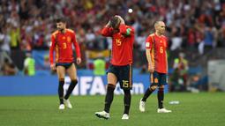 Sergio Ramos (tengah) menutup wajahnya usai kalah dari Rusia pada laga 16 besar Piala Dunia 2018 di Luzhniki Stadium, Moskow, Rusia, (1/7/2018). Spanyol kalah adu penalti 3-4. (AFP/Francisco Leong)