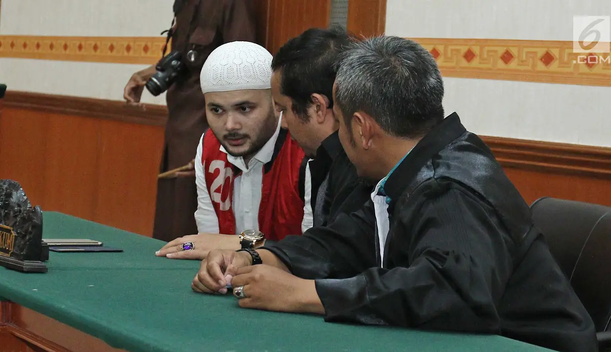Terdakwa Ridho Rhoma berbincang dengan kuasa hukumnya saat menjalani sidang putusan perkara penyalahgunaan narkoba di Pengadilan Negeri Jakarta Barat, Selasa (19/9). (Liputan6.com/Herman Zakharia)