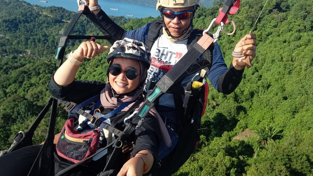 Sensasi terbang dengan paralayang di Kota Padang. (Liputan6.com/ Novia Harlina)