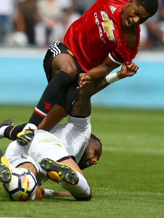 Aksi pemain Manchester United, Marcus Rashford (atas) berebut bola dengan pemain Swansea City, Kyle Bartley pada lanjutan Premier League di Liberty Stadium, Swansea, (19/8/2017). (AFP/Geoff Caddick)