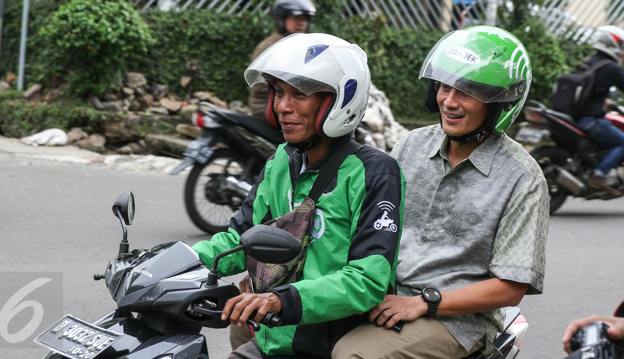 Balon Gubernur DKI Jakarta Sandiaga Uno (belakang) menaiki ojek Gojek untuk menuju kantor Gojek, Jakarta, (1/3). Sandiaga Uno memuji terobosan cerdas Nadiem Makarim menciptakan lapangan kerja dan solusi kemacetan Jakarta. (Liputan6.com/Yoppy Renato)