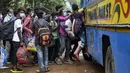 Warga berdesak-desakan untuk naik bus di Kolkata, India, Selasa (21/7/2020). Di tengah lonjakan kasus COVID-19 dalam beberapa minggu terakhir, pemerintah negara bagian di India telah memesan kuncian terfokus di wilayah dengan jumlah kasus tinggi. (AP Photo/Bikas Das)